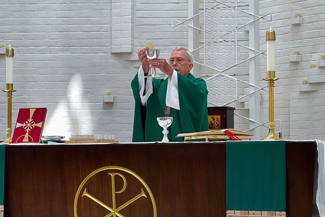 Picture of Rev. Gary Sturni raising the chalice and host. at doxology part of Eucharistic Service at St. Mark's Chapel's 10 AM Rite 2 Service.